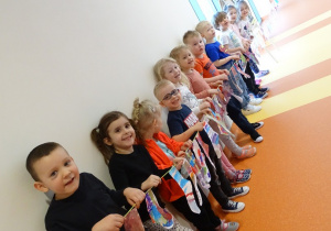 11 Dzieci trzymają sznurek z zawieszonymi kolorowymi skarpetkami